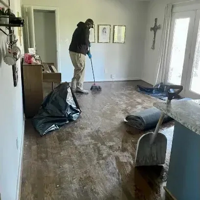 Mud and water being cleaned off a hardwood hallway after a flood